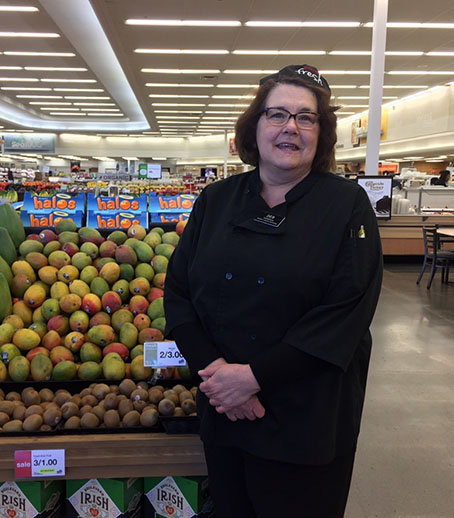 Debbie de pie frente a Mango Produce