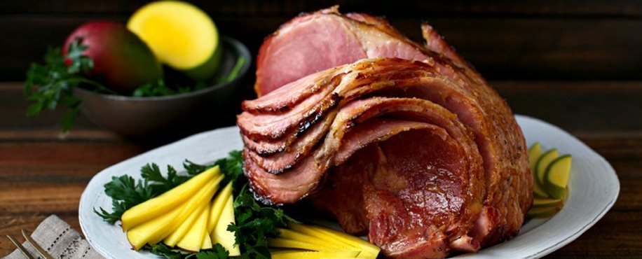 Jamón glaseado con mostaza y mango en un plato